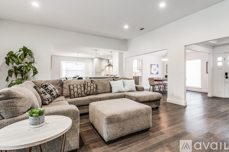 A living room with a grey sofa and a white coffee table.
