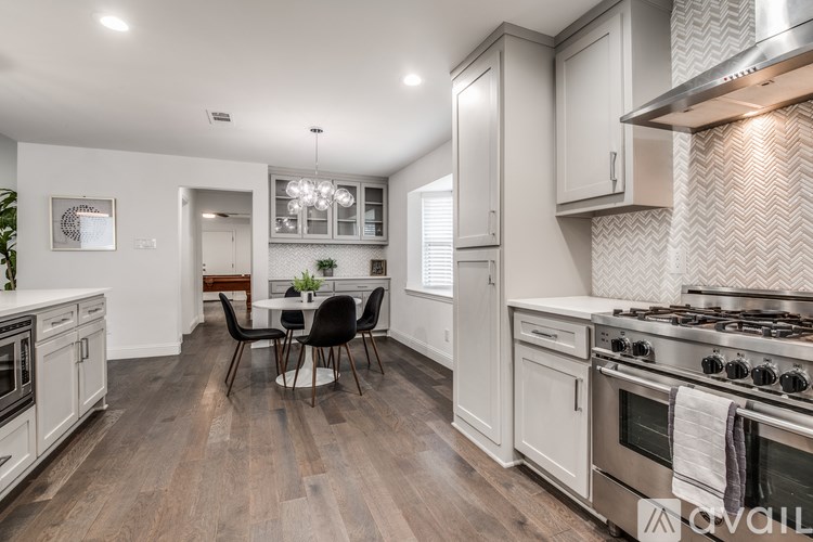 A modern kitchen with a dining table and chairs.