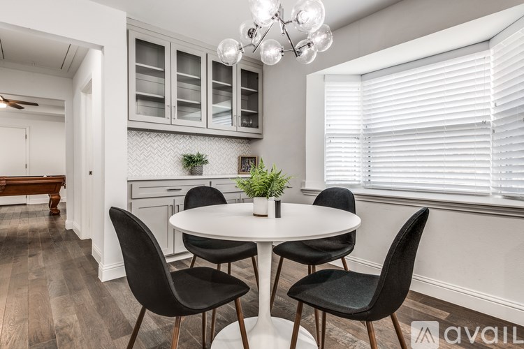 A dining room with a round table and four chairs.
