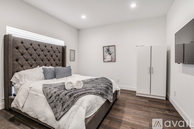A bedroom with a large bed and a wooden headboard.