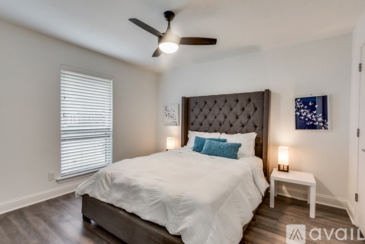 A bedroom with a large bed and a ceiling fan.