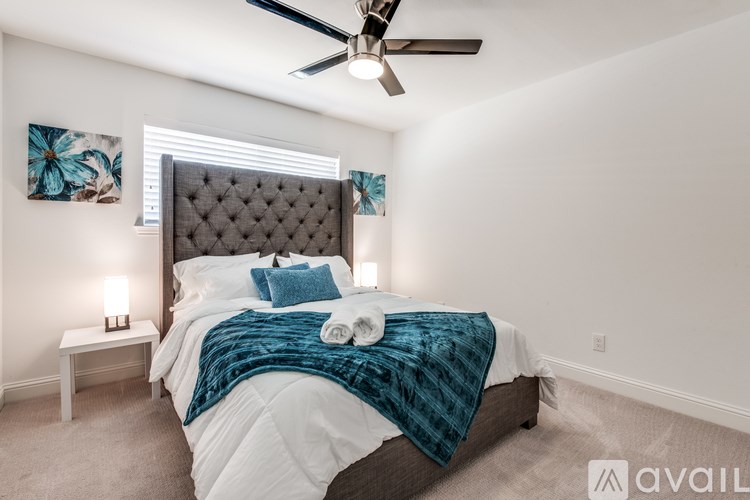 A bedroom with a large bed and a ceiling fan.
