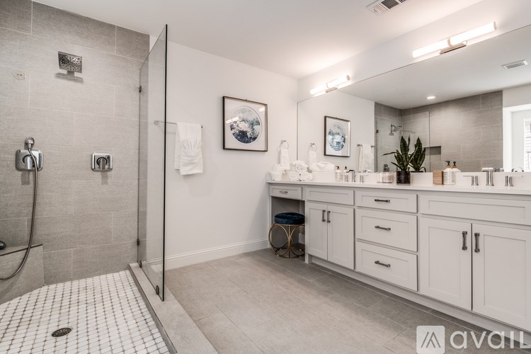 A bathroom with a walk-in shower and double sinks.
