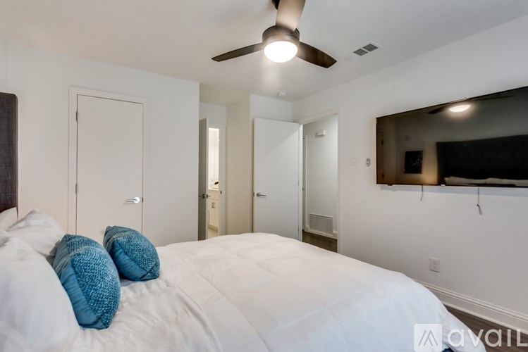 A bedroom with a white bed and blue pillows.