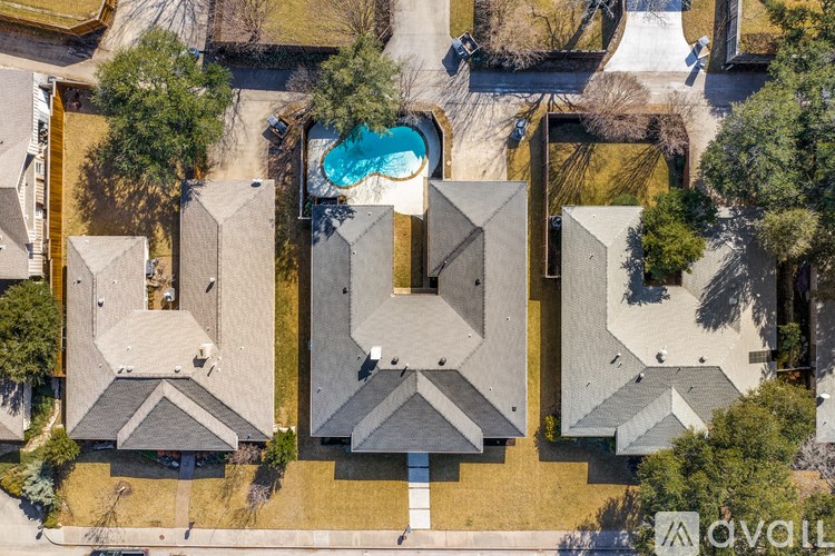 A bird's eye view of a residential area with houses and a swimming pool.