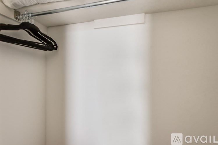 A black hanger is hanging from a white wall.