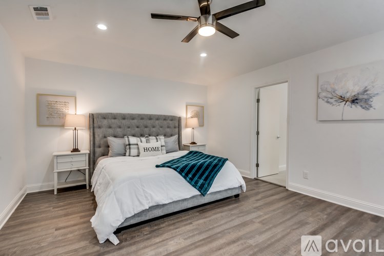 A bedroom with a large bed and a ceiling fan.