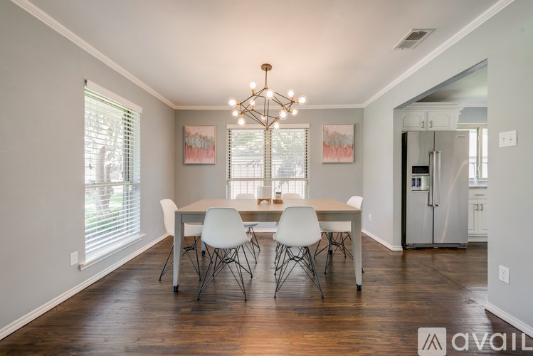 A dining room with a table and chairs and a chandelier.