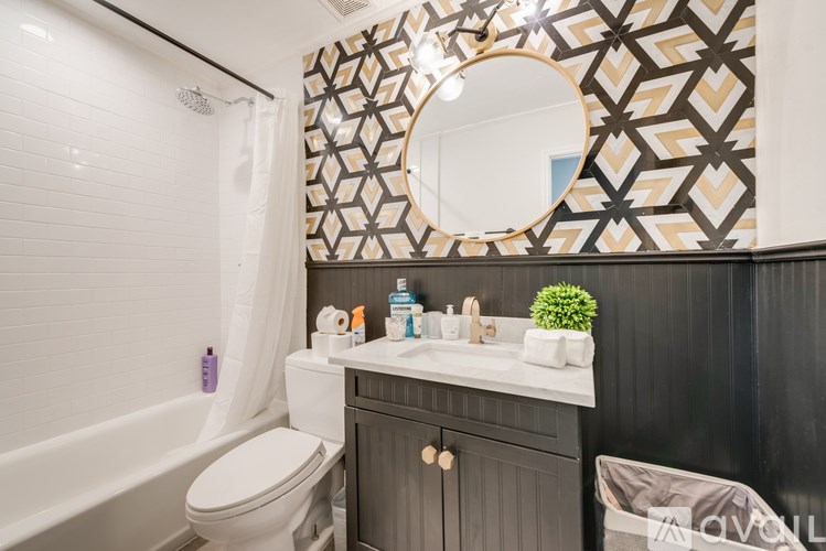 A bathroom with a white toilet, a sink with a mirror above it, and a shower with a white curtain.