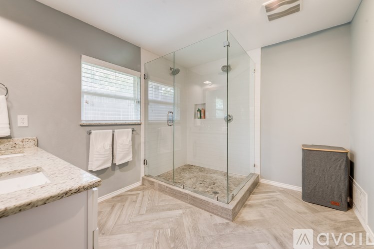 A bathroom with a marble countertop and a walk-in shower.