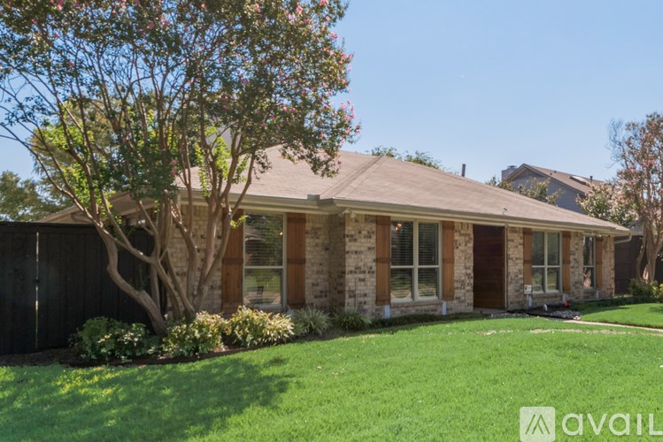 A house with a brown roof and a tree in front of it.