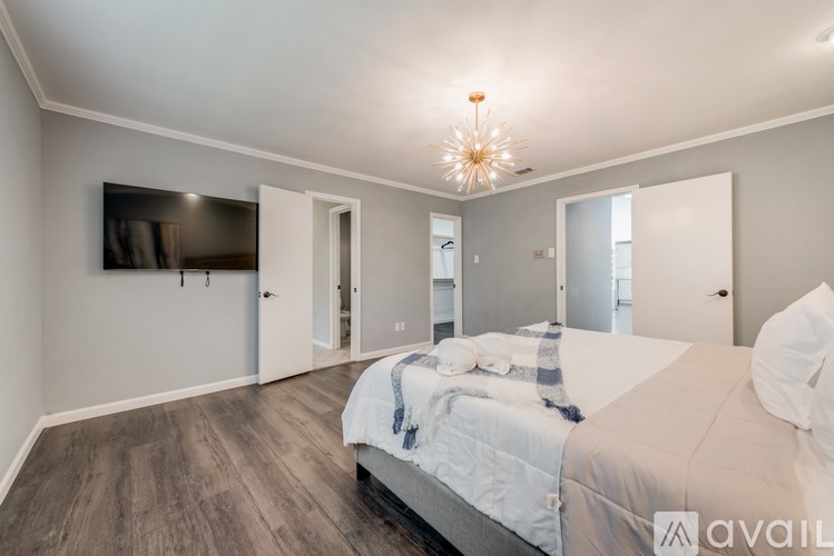 A bedroom with a large bed and a chandelier.