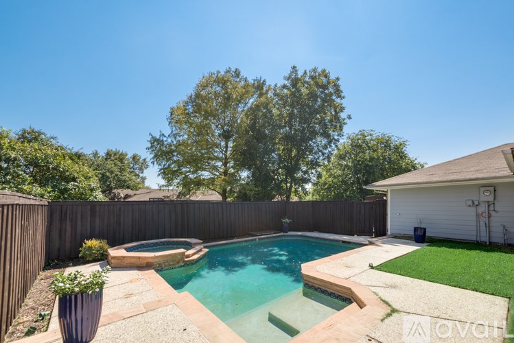 A backyard with a pool and a fence.