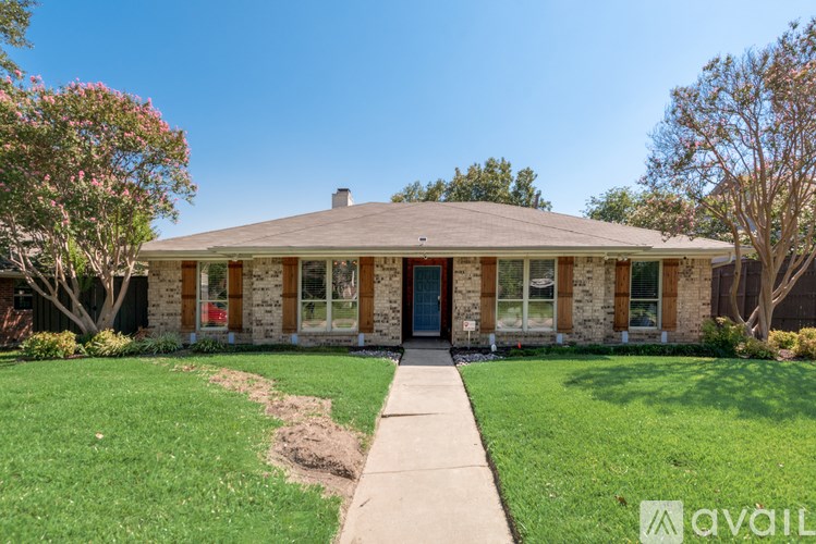 A house with a front yard and a sidewalk leading to the front door.