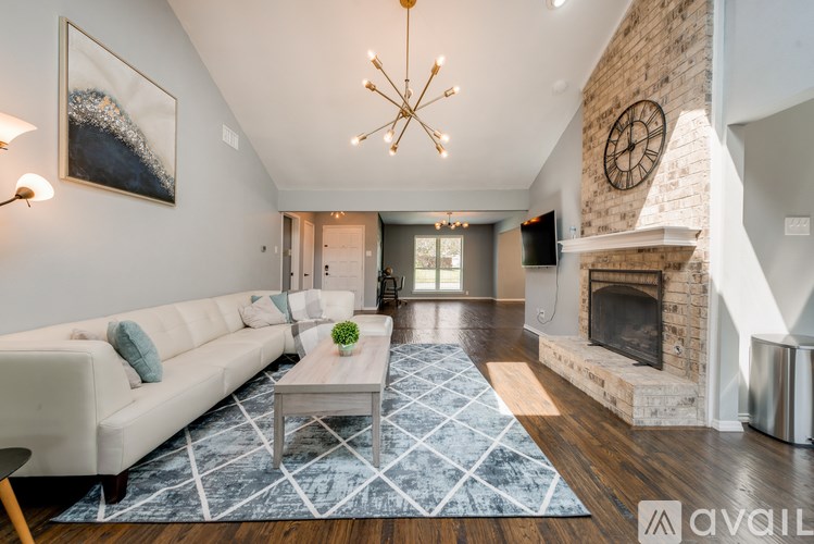 A modern living room with a white sofa and a fireplace.