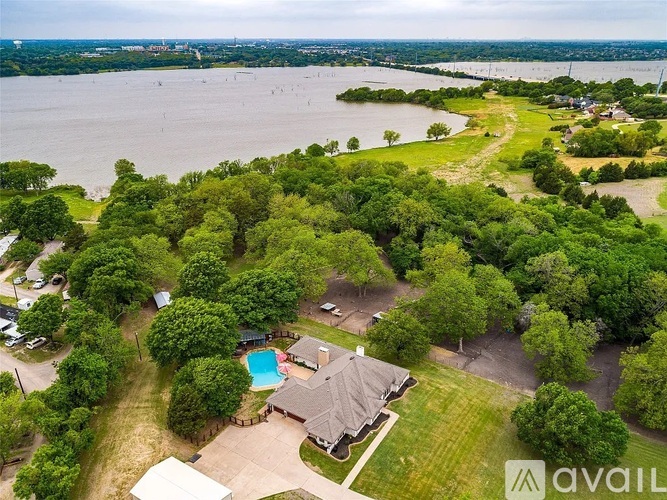 A bird's eye view of a house with a pool surrounded by trees.