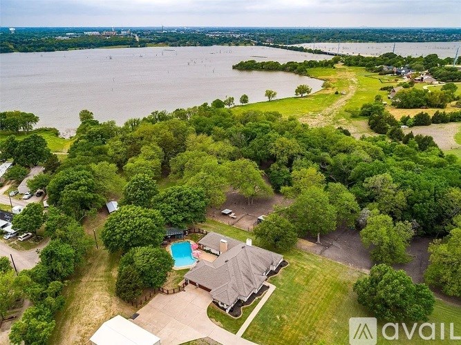 A bird's eye view of a house with a pool surrounded by trees.