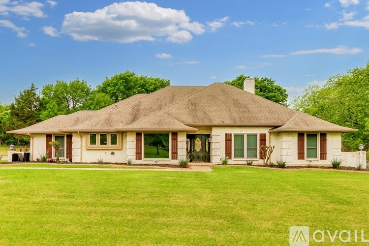 A house with a thatched roof and a green lawn in front.
