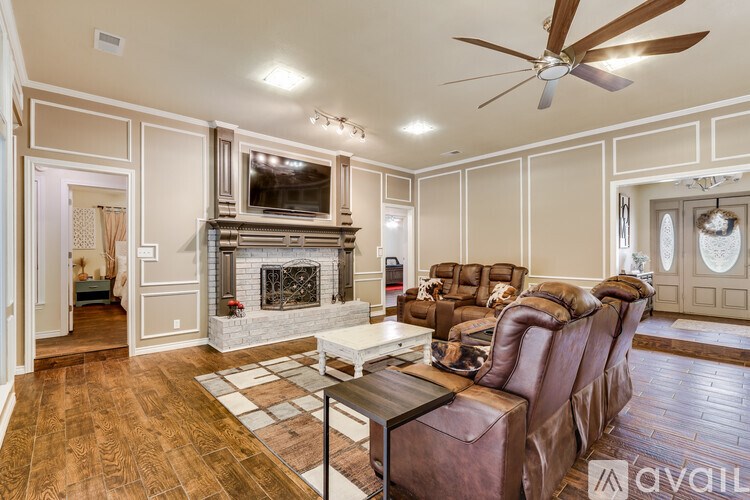 A living room with a fireplace and a brown leather couch.