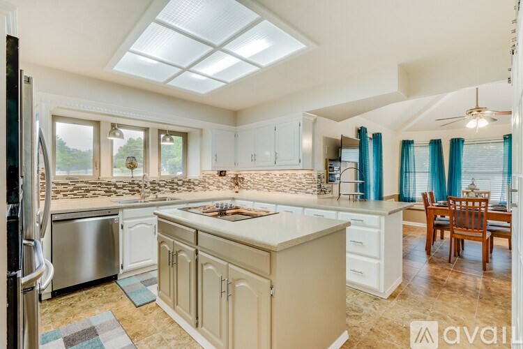 A kitchen with a refrigerator, sink, and cabinets.