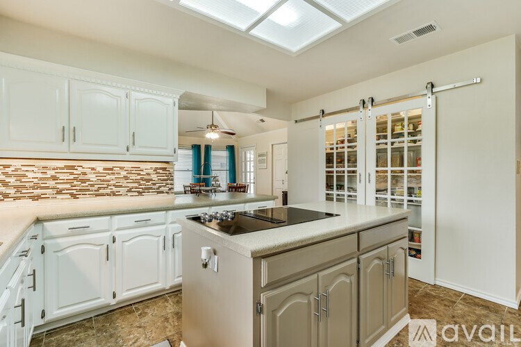 A kitchen with white cabinets and a granite countertop.