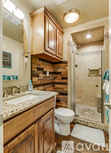 A bathroom with wooden cabinets and a white toilet.