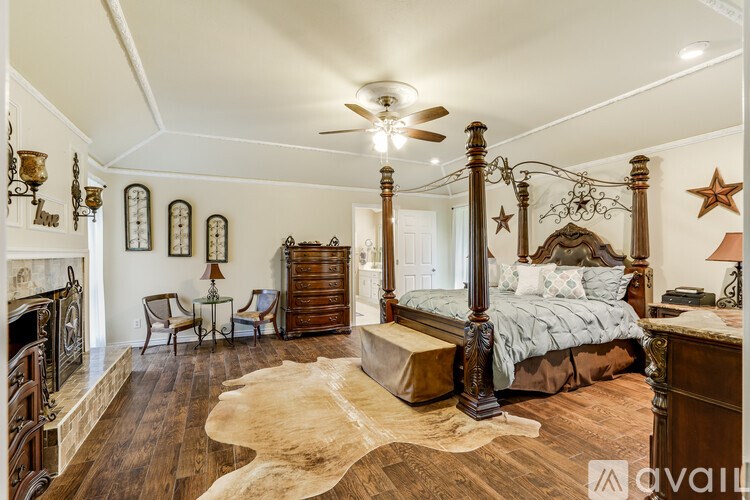 A bedroom with a four poster bed and a cowhide rug.
