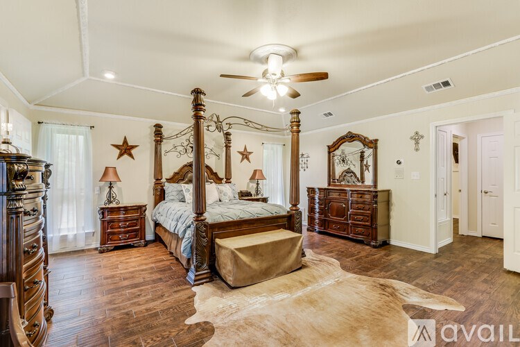 A bedroom with a large bed and a wooden dresser.