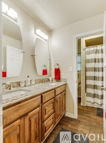 A bathroom with wooden cabinets and marble countertops.