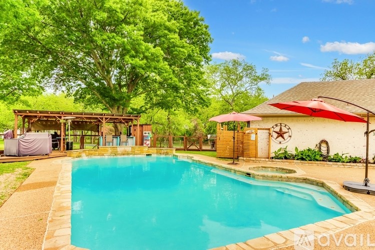 A swimming pool surrounded by a wooden fence and trees.