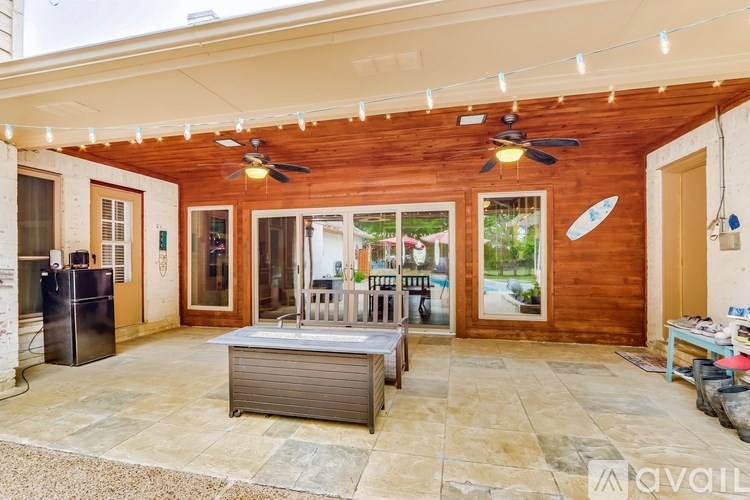 A wooden house with a patio and a hot tub.