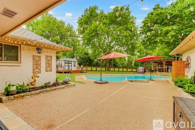 A backyard with a pool and patio furniture.