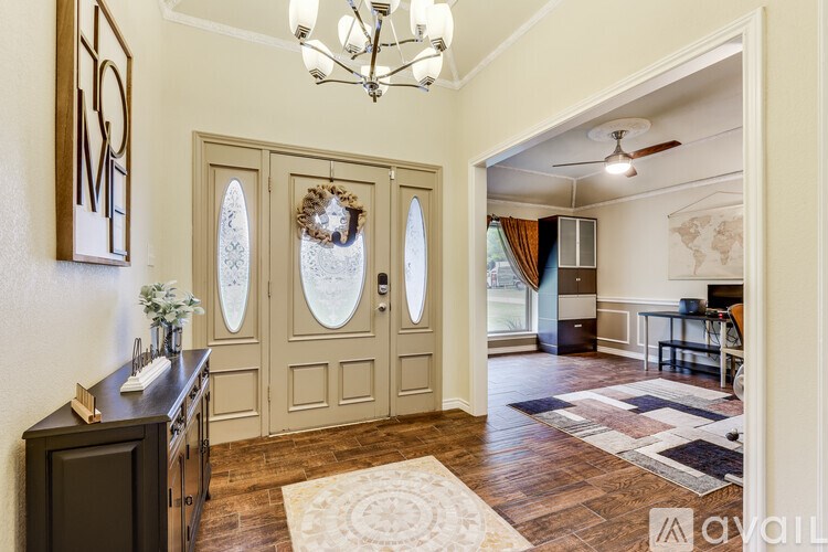 A hallway with a wooden floor and a chandelier.
