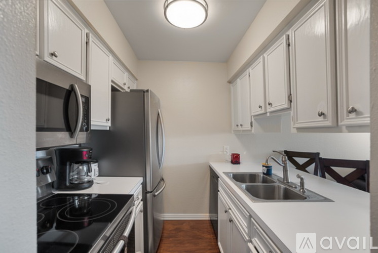 A kitchen with white cabinets and stainless steel appliances.