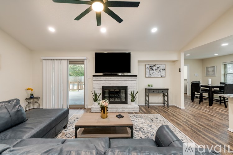 A living room with a grey couch and a fireplace.