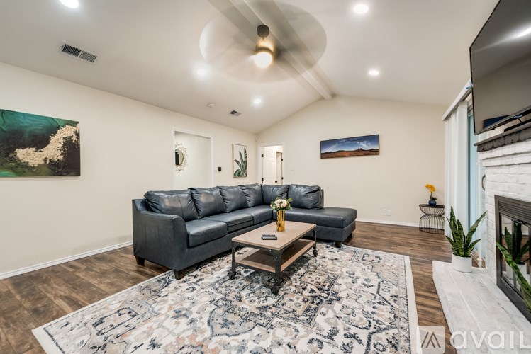 A living room with a grey sofa and a rug.
