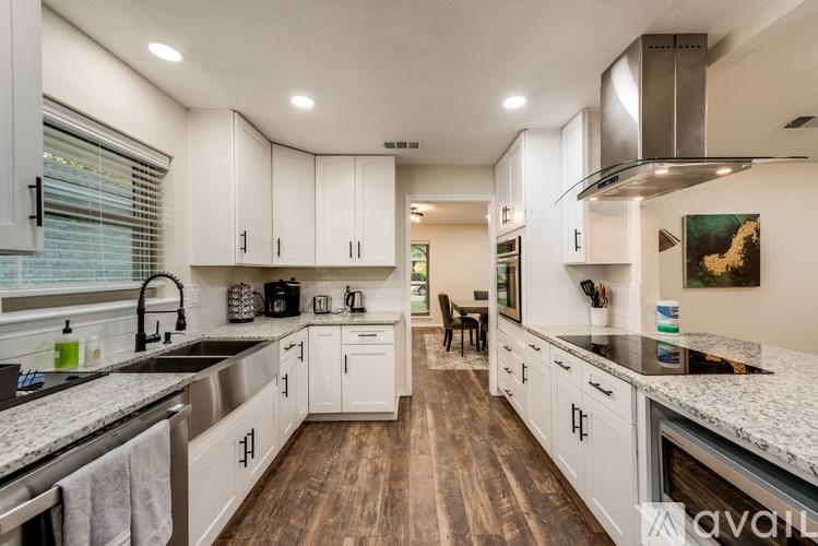 A modern kitchen with white cabinets and stainless steel appliances.