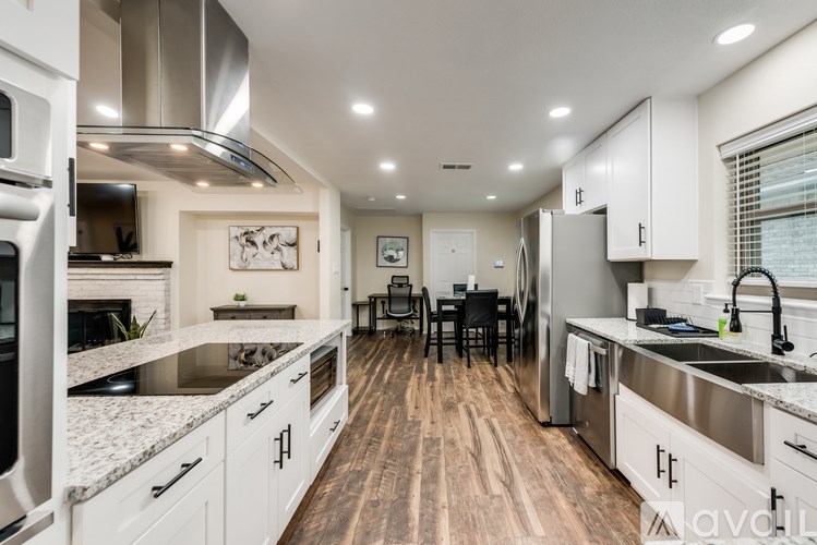 A modern kitchen with stainless steel appliances and wooden floors.