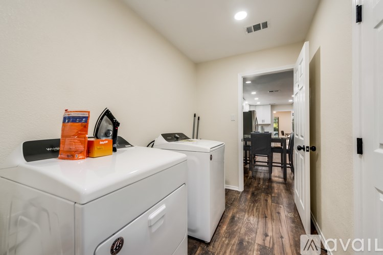 A laundry room with a washer and dryer, a dining area, and a hallway.