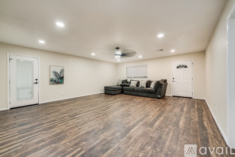 A spacious room with wooden flooring and a couch.