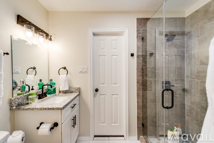 A bathroom with a white door and a marble countertop.
