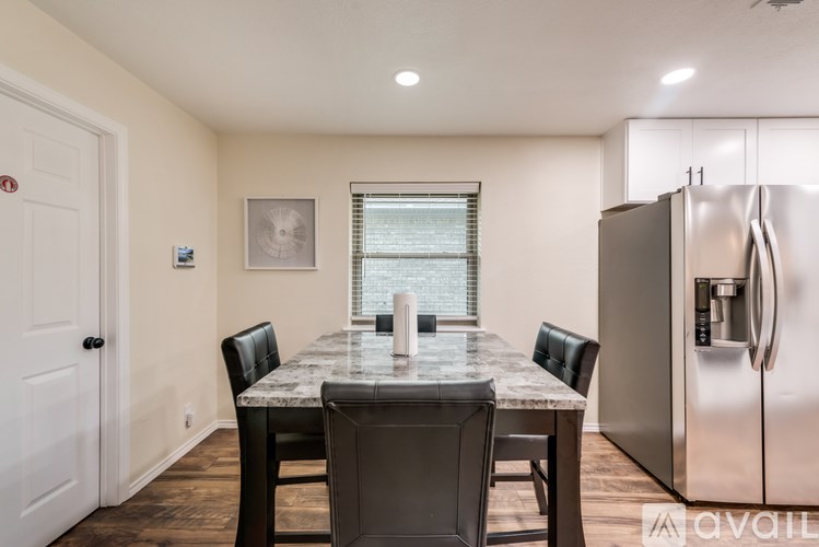 A kitchen with a table and chairs and a refrigerator.