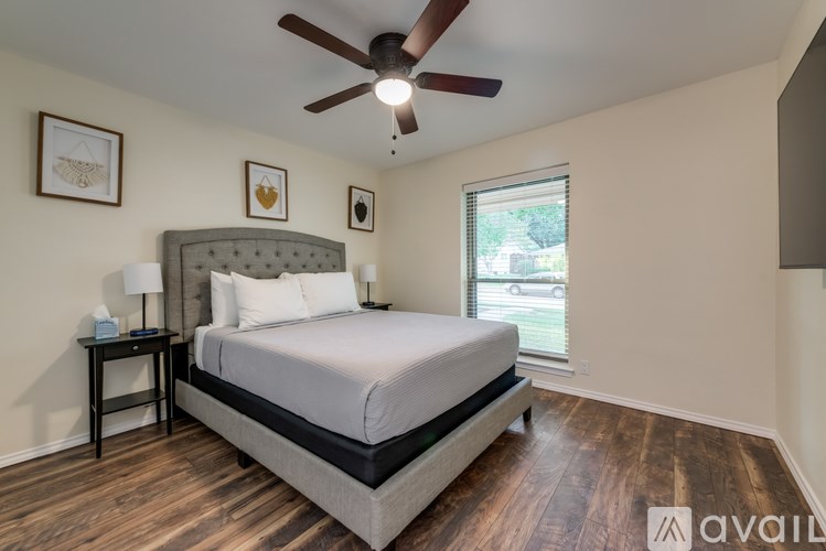 A bedroom with a large bed and a ceiling fan.