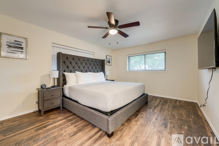A bedroom with a large bed and a ceiling fan.