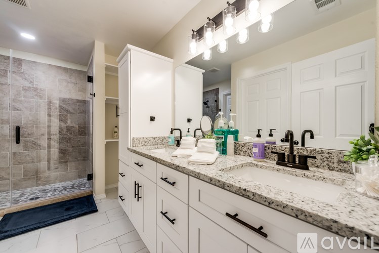 A bathroom with a marble countertop and a walk-in shower.