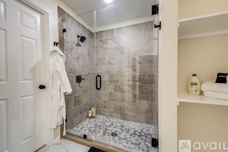 A bathroom with a walk-in shower and a white door.