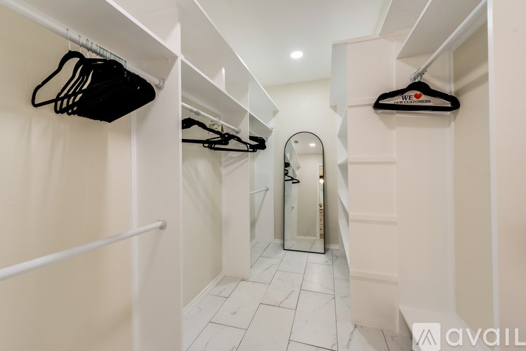 A hallway with a mirror and a coat hanging on the wall.