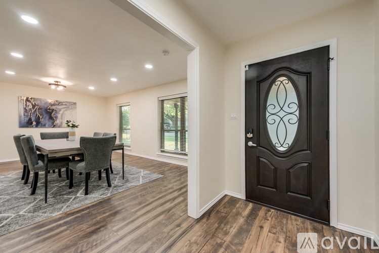 A room with a wooden floor and a large door with a glass window.