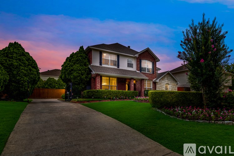 A house with a driveway and a tree in front of it.