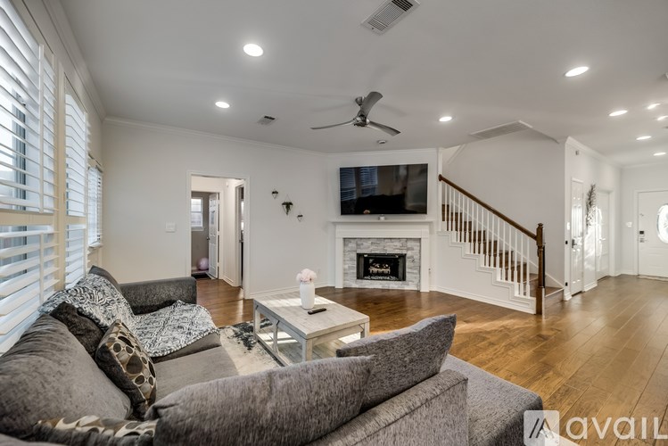 A living room with a grey couch and a fireplace.